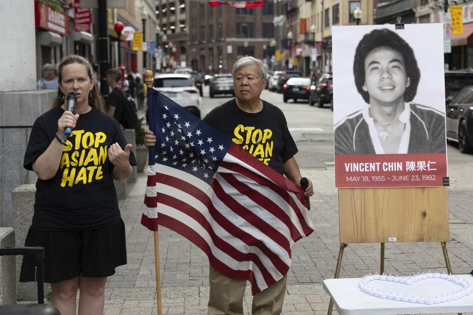 Wilson Lee holds an U.S. flag as Boston City Councilor Erin Murphy speaks during a remembrance ceremony for Vincent Chin in Chinatown, Sunday, June 23, 2024, in Boston. Over the weekend, vigils were held across the country to honor the memory of Chin, who was killed by two white men in 1982 in Detroit. (AP Photo/Michael Dwyer)