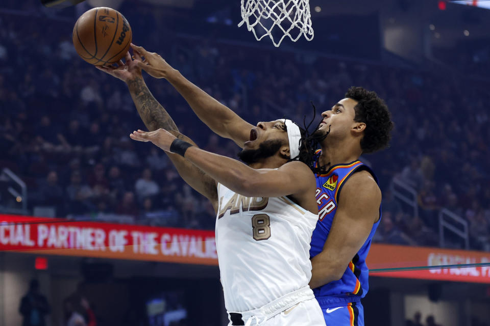 Oklahoma City Thunder forward Jeremiah Robinson-Earl, right, blocks a shot by Cleveland Cavaliers forward Lamar Stevens (8) during the first half of an NBA basketball game, Saturday, Dec. 10, 2022, in Cleveland. (AP Photo/Ron Schwane)