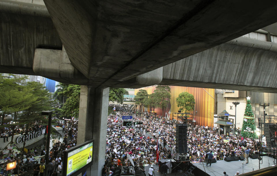 In this photo taken Jan. 15, 2014, anti-government protesters gather during a rally led by former deputy prime minister Suthep Thaugsuban at Ratchabrasong intersection in Bangkok, Thailand. Four years ago Suthep ordered a crackdown that saw the army rip through anti-government protesters’ tire-and-bamboo-barricaded encampments and fire M-16s into crowds of fleeing protesters. Today, he is leading a protest movement that has itself blocked roads and broken into government offices - an extraordinary role reversal that underscores not only the cyclical nature of Thai politics, but the total lack of progress toward bridging a political divide that has plagued the country for nearly a decade. Among the places his supporters occupy is the place the Red Shirts made their last stand four years ago: Ratchaprasong, the country’s glitziest intersection, where just like the Red Shirts, protesters are camping in the middle of the road, in front of a huge stage complete with speakers and a giant video screen. (AP Photo/Sakchai Lalit)