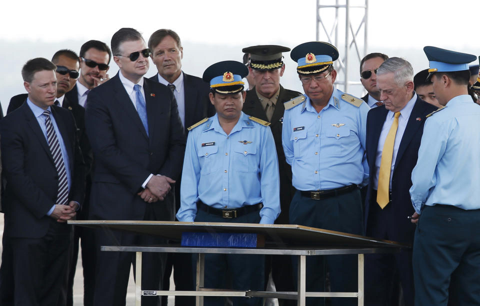 U.S. Secretary of Defense Jim Mattis, second from right, is guided by Vietnam's Air Force Deputy Commander Gen. Bui Anh Chung, third from right, during his visit to Bien Hoa airbase, where the U.S. army stored the defoliant Agent Orange during the Vietnam War, in Bien Hoa city, outside Ho Chi Minh city, Vietnam, Wednesday, Oct. 17, 2018. (Kham/Pool Photo via AP)