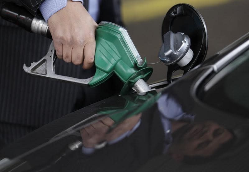 A customer fills his Aston Martin DB9 car at a petrol station, in south London, March 2, 2011. REUTERS/Andrew Winning