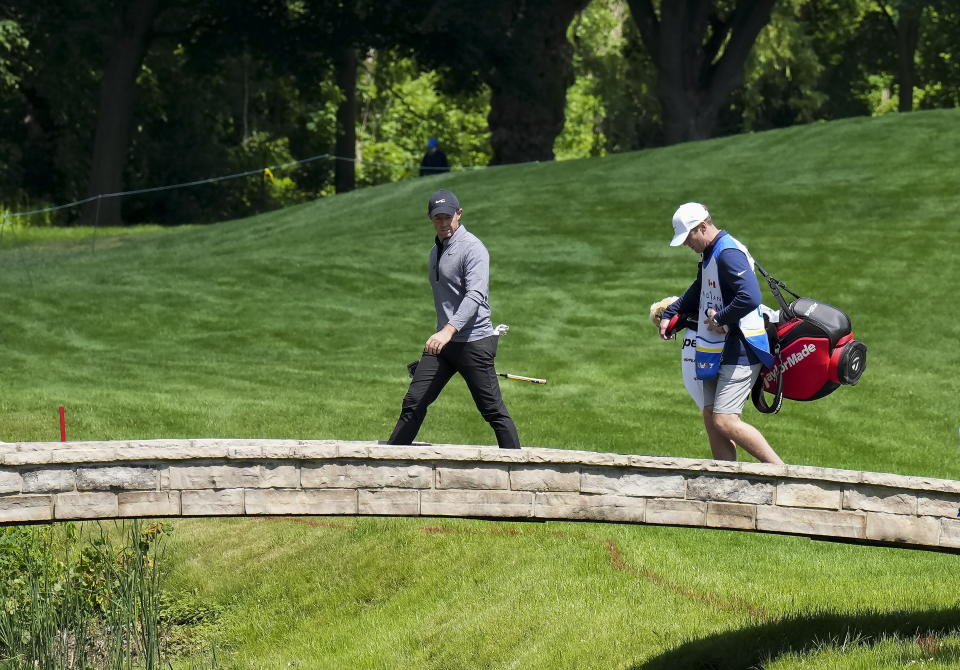 Rory McIlroy, left, and his caddie cross a bridge on the 14th hole during the Canadian Open golf pro-am in Toronto on Wednesday, June 8, 2022. (Nathan Denette/The Canadian Press via AP)