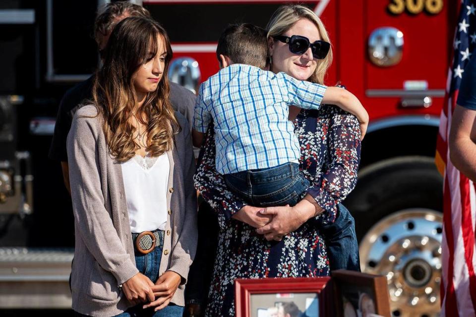 Jennifer Rotondaro, right, holds son Wyatt, 5, with daughter Kiersten, 17, left, during a ceremony dedicating a section of Highway 140 near Gustine for her late husband and Cal Fire Capt. Paul Vincent Rotondaro, in Merced County, Calif., on Monday, Sept. 18, 2023. Rotondaro was killed in a traffic collision while on duty in Merced County on Oct. 2, 2019.