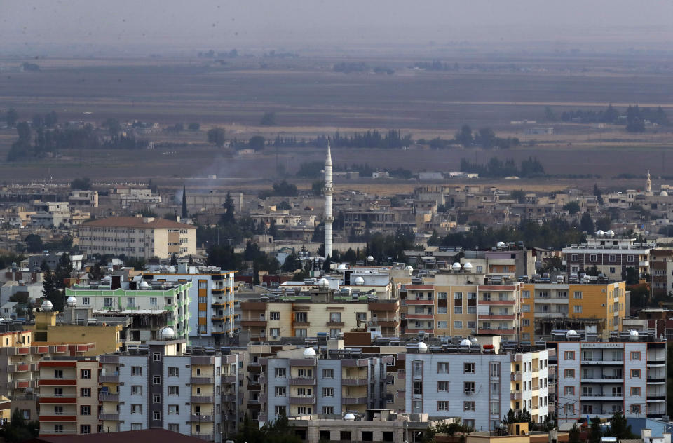 In this photo taken from the Turkish side of the border between Turkey and Syria, in Ceylanpinar, Sanliurfa province, southeastern Turkey, a new of Ras al-Ayn, Syria, Friday, Oct. 18, 2019. Fighting broke out in the morning hours in the Syrian border town which has been a flashpoint in the fight between Turkey and Kurdish forces despite a U.S.-brokered cease-fire that went into effect overnight. The fighting died down in mid-morning. (AP Photo/Lefteris Pitarakis)