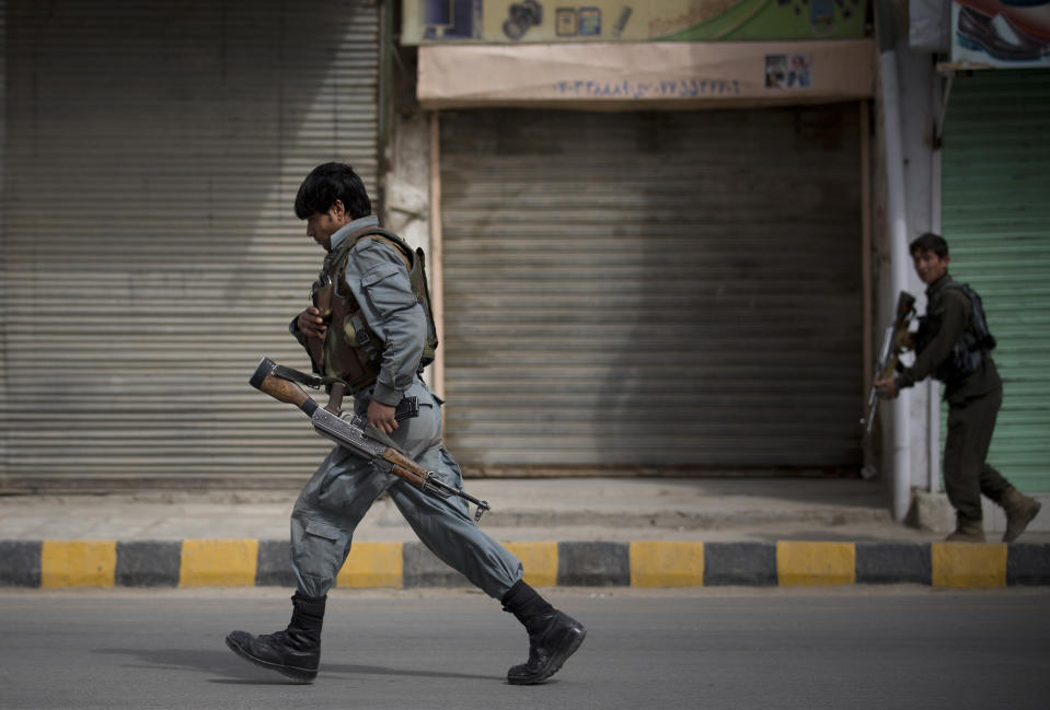 Afghan police men take position after an attack by a suicide squad on the former Afghan intelligence headquarters in the center of Kandahar, Afghanistan, Wednesday, March 12, 2014. Police officials said three insurgents who tried to storm the former headquarters of Afghanistan’s intelligence service in southern Kandahar died in a gunbattle with security forces. (AP Photo/Anja Niedringhaus)