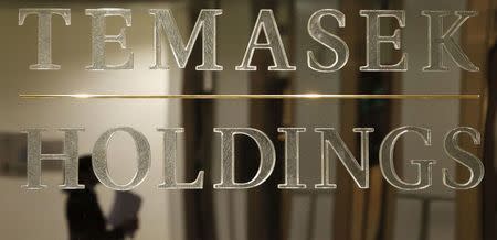 A staff member is reflected in a Temasek Holdings logo at their headquarters before the presentation of Temasek's annual review in Singapore in this September 17, 2009 file photo. REUTERS/Vivek Prakash/Files