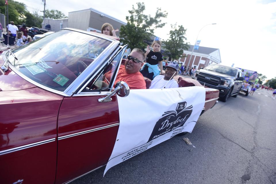 A parade volunteer drives a 1964 Chevrolet Impala on Huron Avenue during the annual Rotary International Day Parade to kick off Port Huron's Boat Week on Wednesday, July 13, 2022.