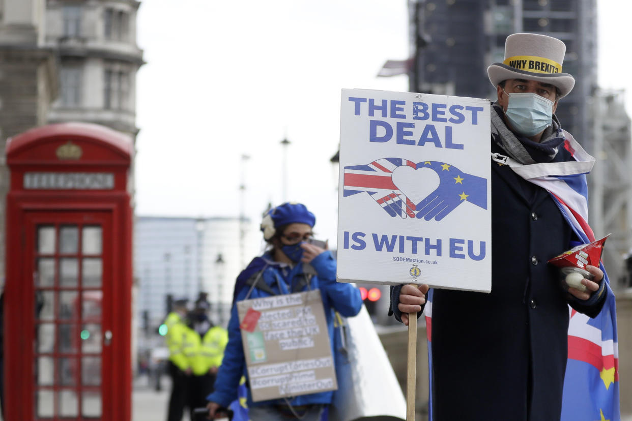 Steve Bray, right, a pro EU campaigner during a protest against a Brexit no deal near Parliament in London, Wednesday, Nov. 25, 2020. The European Union has committed to be "creative" in the final stages of the Brexit trade negotiations but warned that whatever deal emerges, the United Kingdom will be reduced to "just a valued partner," far removed from its former membership status. (AP Photo/Kirsty Wigglesworth)