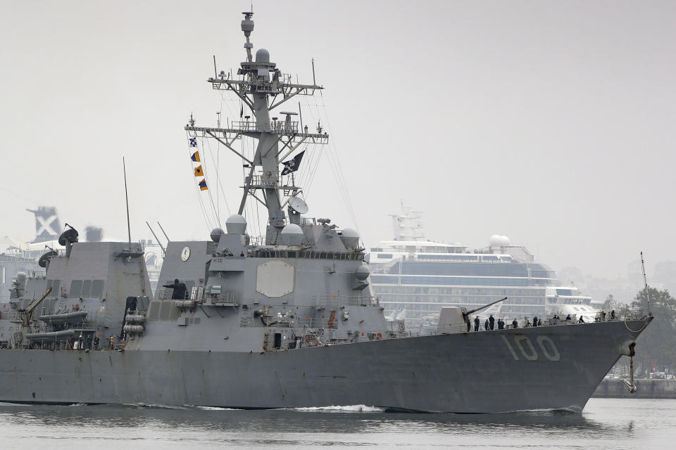 The USS Kidd flies its traditional skull and crossbones flag while passing downtown San Diego as it returns to Naval Base San Diego, Tuesday, April 28, 2020, as seen from Coronado, Calif. As the American destroyer heads home with an outbreak in cases of COVID-19, relatives and friends of the 350 crew members prayed for their health while Navy officials vowed to keep the outbreak, the second to strike a Navy vessel at sea, from spreading. (AP Photo/Gregory Bull)