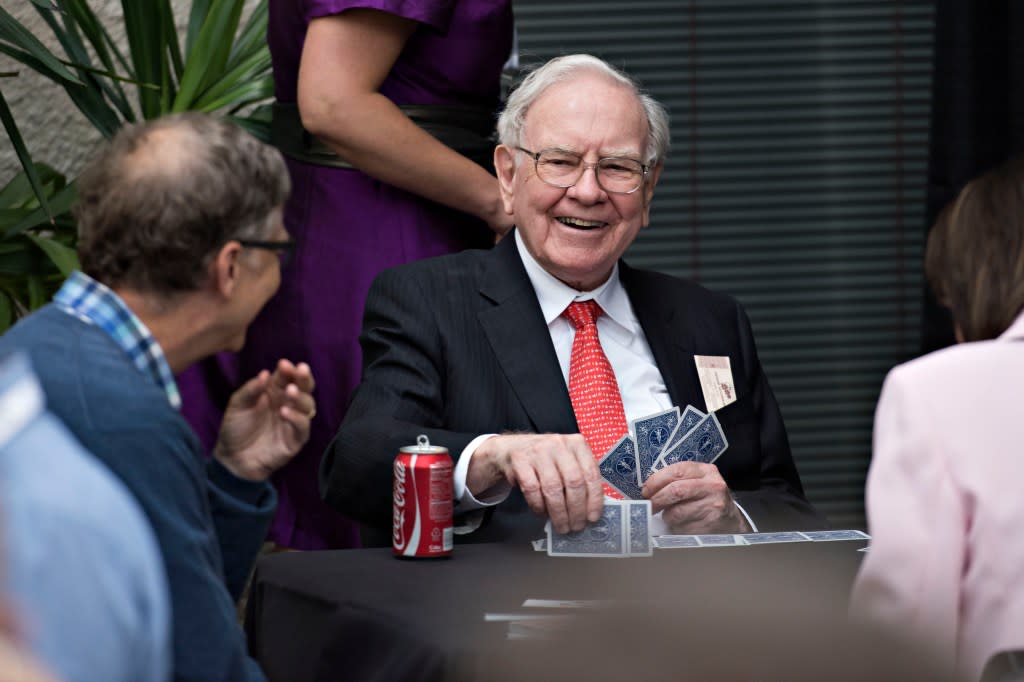 Warren Buffett, chairman of Berkshire Hathaway Inc., center, laughs with Bill Gates, chairman and founder of Microsoft Corp. and a Berkshire Hathaway Inc. director, left, as they play bridge during a shareholder event on the sidelines of the Berkshire Hathaway Inc. annual shareholders meeting in Omaha, Nebraska, U.S., on Sunday, May 3, 2015. More than 40,000 people were expected to attend yesterday's Berkshire Hathaway annual meeting, which marks Warren Buffett's 50th year running the company. Photographer: Daniel Acker/Bloomberg via Getty Images