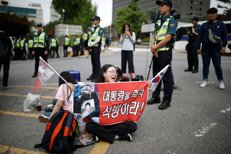 A supporter of South Korean ousted leader Park Geun-hye cries as she holds a banner that reads "release President immediately" in front of a court in Seoul, South Korea, May 23, 2017. REUTERS/Kim Hong-Ji