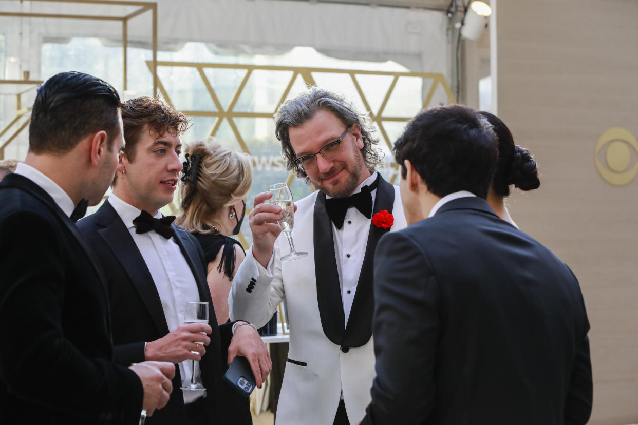 People in formal wear and holding glasses gather.