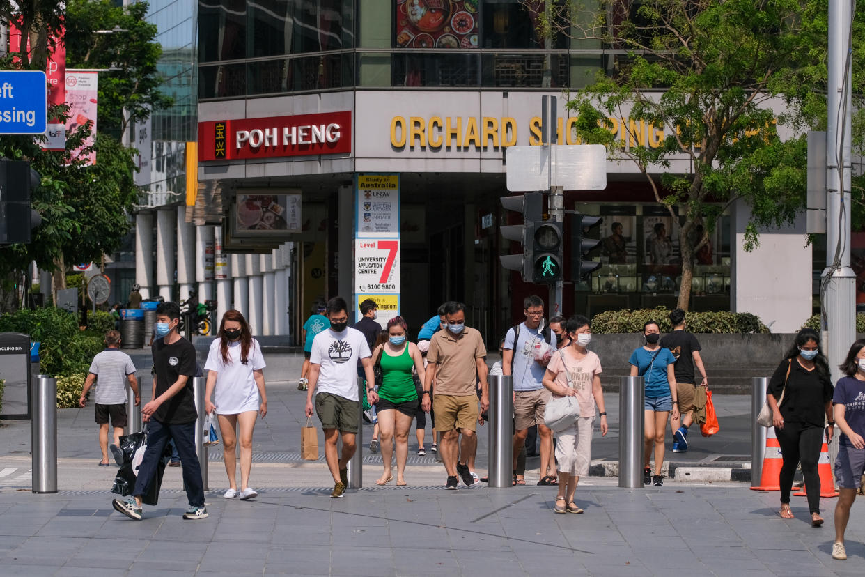 SINGAPORE - 2021/05/16: People wearing face masks as a preventive measure against the spread of covid-19 walk across a Street in Singapore.
Singapore tightens its Covid-19 restrictions from May 16 to June 13 due to the rise of Covid-19 cases in the community. During this time, only groups of 2 people outside will be allowed, malls and attractions are to reduce capacity, and dining-in at eateries are prohibited. (Photo by Maverick Asio/SOPA Images/LightRocket via Getty Images)