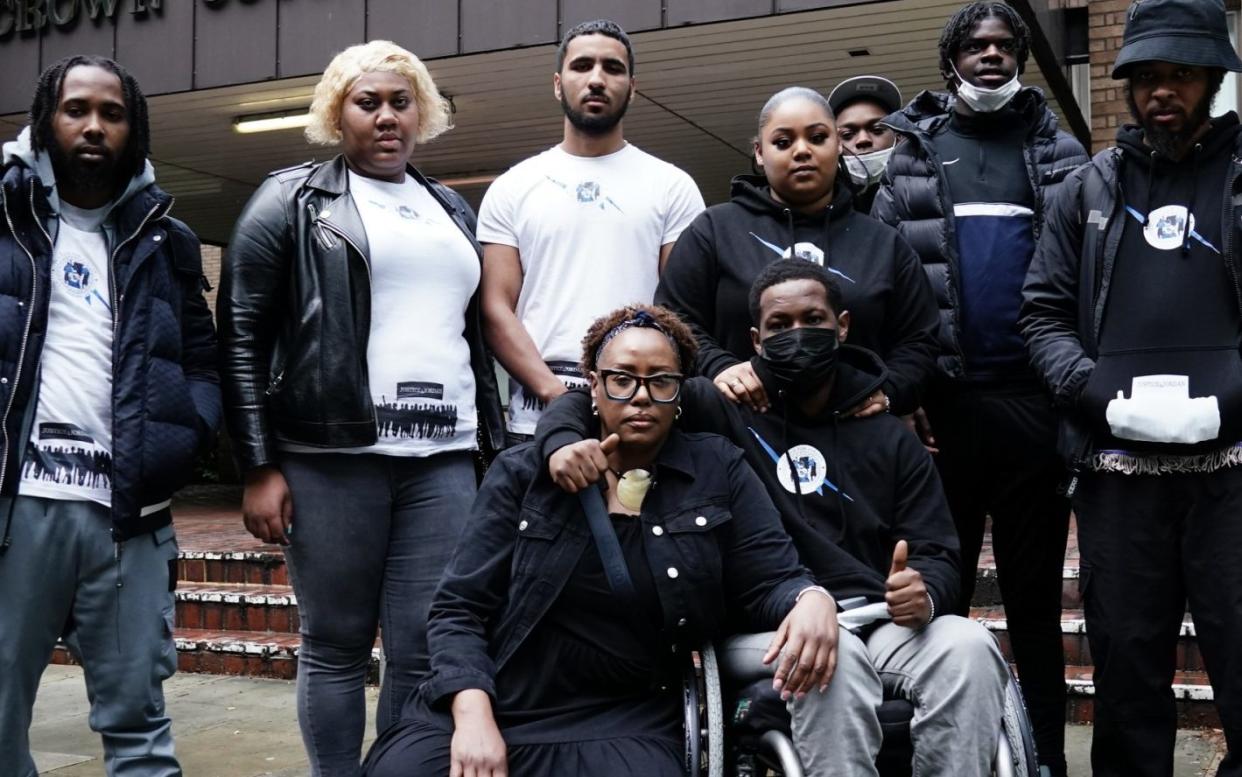 Jordan Walker-Brown in a wheelchair, with supporters, outside Southwark Crown Court, south London