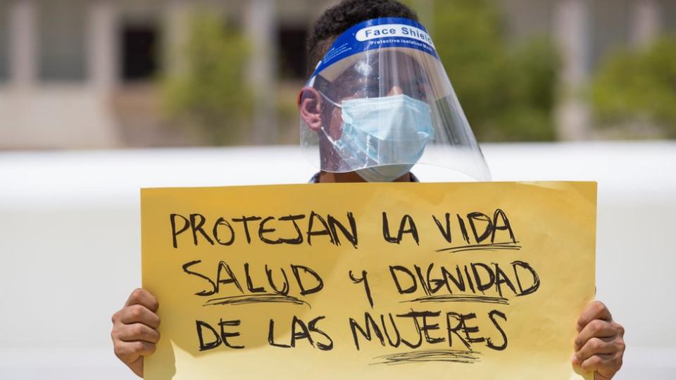 Joven con un cartel en defensa de las mujeres en Santo Domingo, República Dominicana