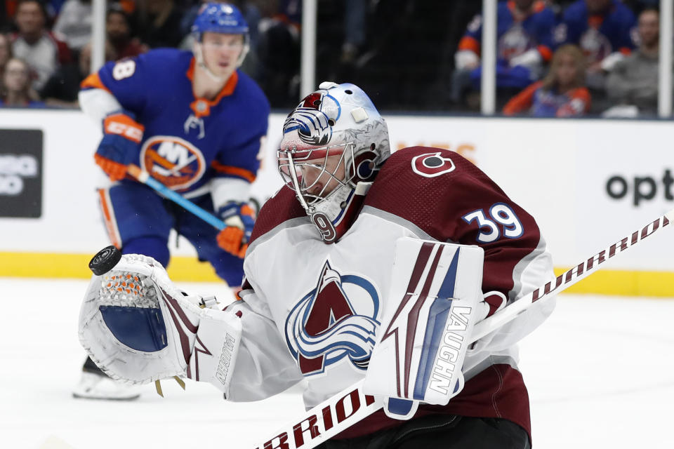 Colorado Avalanche goaltender Pavel Francouz (39) makes a save as New York Islanders defenseman Noah Dobson (8) watches during the second period of an NHL hockey game, Monday, Jan. 6, 2020, in Uniondale, N.Y. (AP Photo/Kathy Willens)