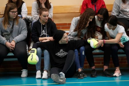 Students check out the gloves of Miriam Gutierrez "La Reina", 36, after she talked to them about gender violence and bullying in Alconchel