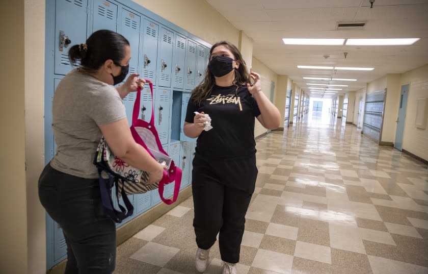 WOODLAND HILLS, CA - APRIL 30: Jamie Zamudio, left, helps her daughter Isabella, 14, a freshman clean out her locker at El Camino Real Charter High School on Thursday, April 30, 2020 in Woodland Hills, CA. School officials were allowing no more than 5 students at a time on campus to take home their belongings. School officials were allowing no more than 5 students at a time on campus to take home their belongings. (Brian van der Brug / Los Angeles Times)