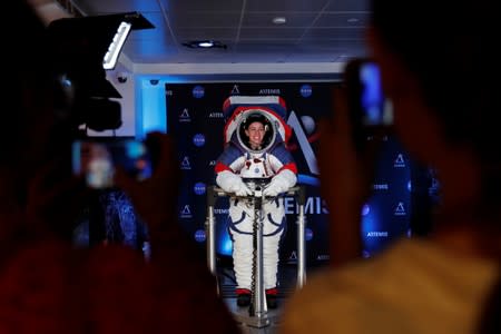 Visitors take pictures of Advanced Space Suit Engineer at NASA Kristine Davis as she wears the xEMU prototype space suit for the next astronaut to the moon by 2024, during its presentation at NASA headquarters in Washington