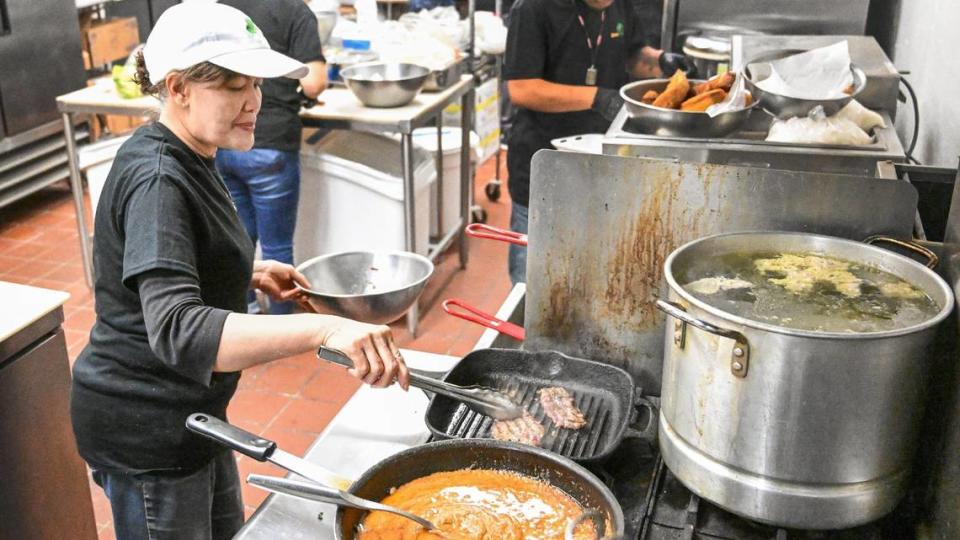 Bounma Rasavong works in the kitchen at Love & Thai during their soft opening on Wednesday, Oct. 3, 2023. The Rasavong family ran the former Tasty Thai restaurant before it closed after false allegations of serving dog meat surfaced online. Their new restaurant is opening in the shopping center at South Chestnut and East Butler avenues in southeast Fresno.