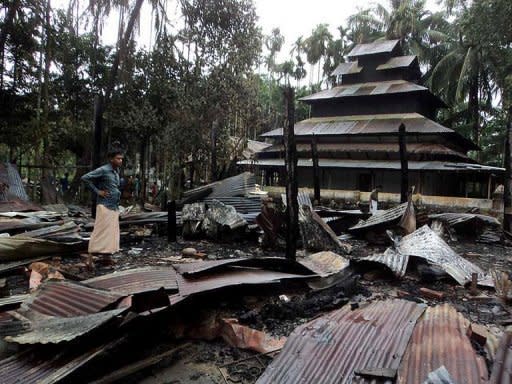 A Bangladeshi man stands amidst the torched ruins of the Buddhist temple called Ramu Moitree Bihar (Ramu Friendship Temple) at Ramu. Sectarian tensions have been running high since June when deadly clashes erupted between Buddhists and Muslim Rohingya in Myanmar's western Rakhine state