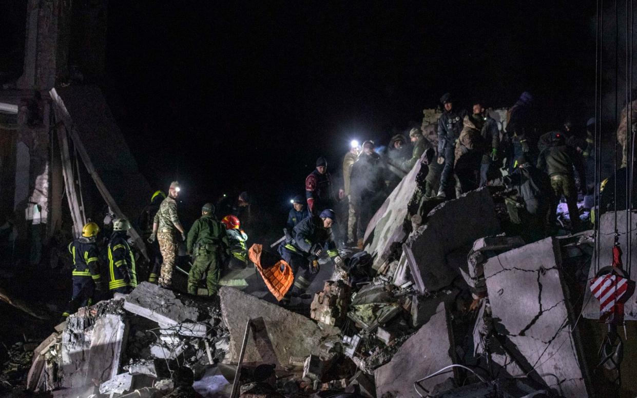 Rescue workers, clear rubble and search for bodies, at the scene of a Russian missile strike in central Kramatorsk late on Wednesday evening - JULIAN SIMMONDS/The Telegraph