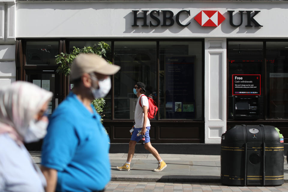 People wearing face covering pass a HSBC UK branch near Covent Garden in London, as the bank has announced to accelerate plans to cut 35,000 jobs globally after the Covid-19 crisis forced the bank to put aside another $3.8bn (�2.9bn) to cover bad debts. Picture date: Friday August 7, 2020.