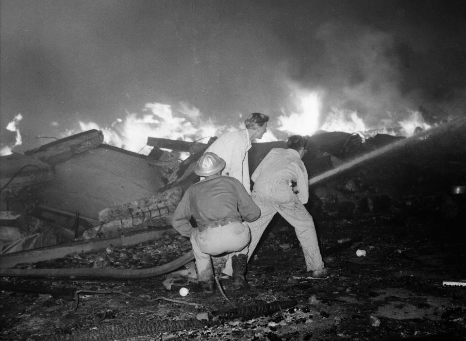 Firefighters work to put out a fire near the blast crater in 1959.