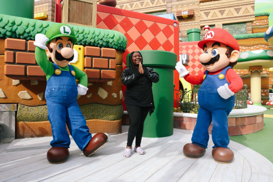 LJ Hale poses with Luigi and Mario at Super Nintendo World