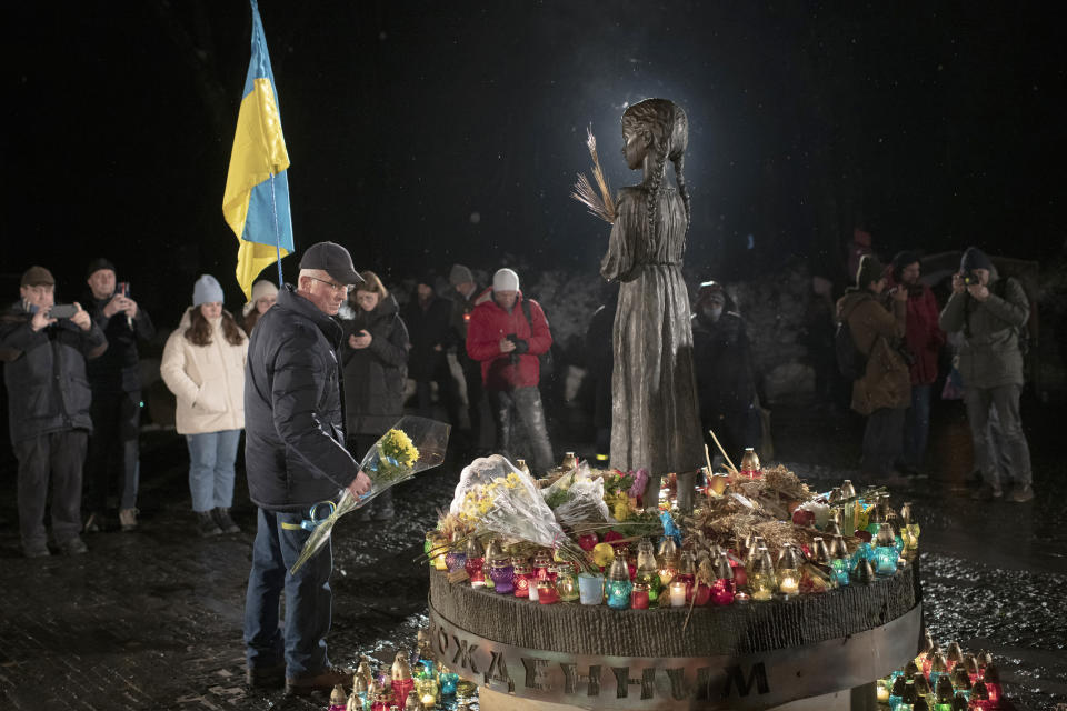 People light candles and lay flowers at the monument of the victims of the Holodomor, Great Famine, which took place in the 1930's and that killed millions, in Kyiv, Ukraine, Saturday, Nov. 26, 2022. (AP Photo/Andrew Kravchenko)