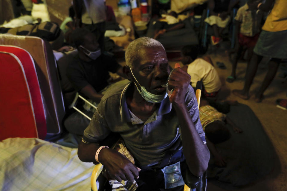 An elderly man drinks water inside a shelter for displaced Haitians, in Port-au-Prince, Haiti, Saturday, July 10, 2021, three days after Haitian President Jovenel Moise was assassinated in his home. The displaced Haitians were forced to flee their community where they had settled after the 2010 earthquake, after armed gangs set their homes on fire in late June. (AP Photo/Fernando Llano)