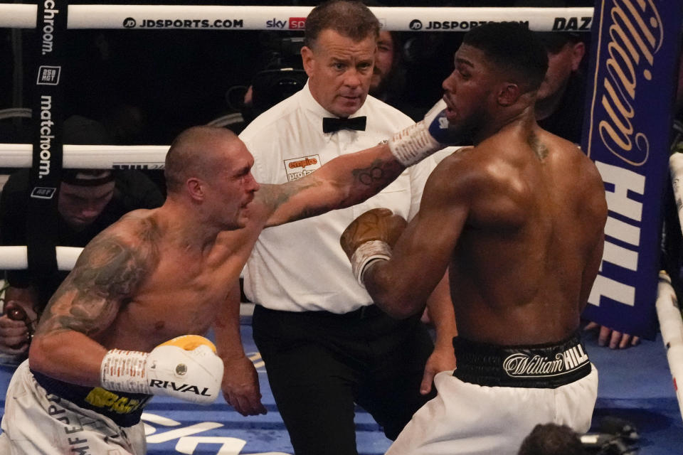 Oleksandr Usyk of Ukraine, left, throws a punch at Anthony Joshua of Britain during their WBA (Super), WBO and IBF boxing title bout at the Tottenham Hotspur Stadium in London, Saturday, Sept. 25, 2021. (AP Photo/Frank Augstein)