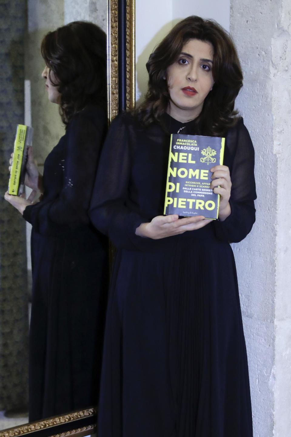 PR agent Francesca Chaouqui holds up her book 'In the Name of Peter' (Nel Nome di Pietro), a behind-the-scenes drama of a papal reform commission that ended in disgrace after its documents were leaked to two journalists, during an interview with the Associated Press, in Rome, Monday, Feb. 6, 2017. Chaouqui received a suspended sentence for her role in the leaks, and is tempting Vatican prosecutors by publishing confidential documents in her book that hits bookstores Tuesday (AP Photo/Andrew Medichini)