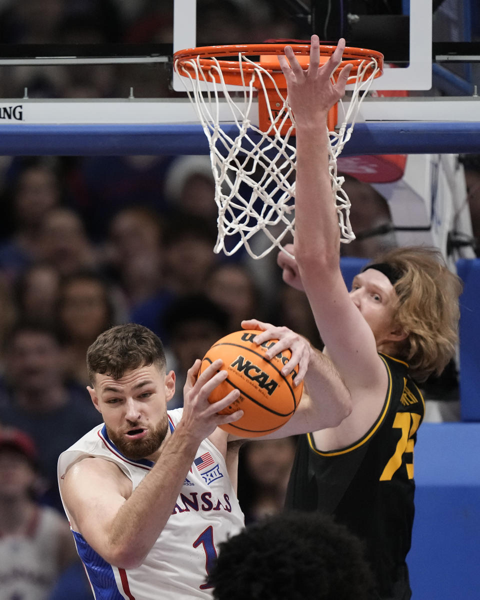 Kansas center Hunter Dickinson (1) beats Missouri center Connor Vanover (75) to a rebound during the first half of an NCAA college basketball game Saturday, Dec. 9, 2023, in Lawrence, Kan. (AP Photo/Charlie Riedel)