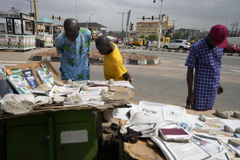 People check local newspapers with preliminary presidential election results in Lagos, Nigeria, Monday, Feb. 27, 2023. Each of the three frontrunners in Nigeria's hotly contested presidential election claimed they were on the path to victory Monday, as preliminary results trickled in two days after Africa's most populous nation went to the polls. (AP Photo/Sunday Alamba)
