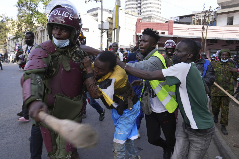 A suspected thief is rescued by Kenya's anti-riot police from members of the public after he attempted to snatch a mobile phone in downtown Nairobi, Kenya Tuesday, July 2, 2024. Protests have continued to rock several towns in Kenya including the capital Nairobi, despite the president saying he will not sign a controversial finance bill that sparked deadly protests last week. (AP Photo/Brian Inganga)