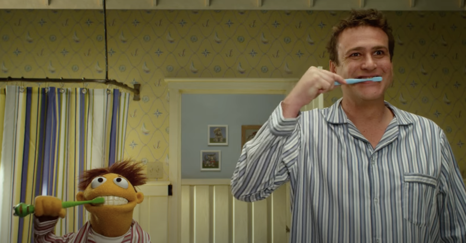 a man and a muppet brushing their teeth