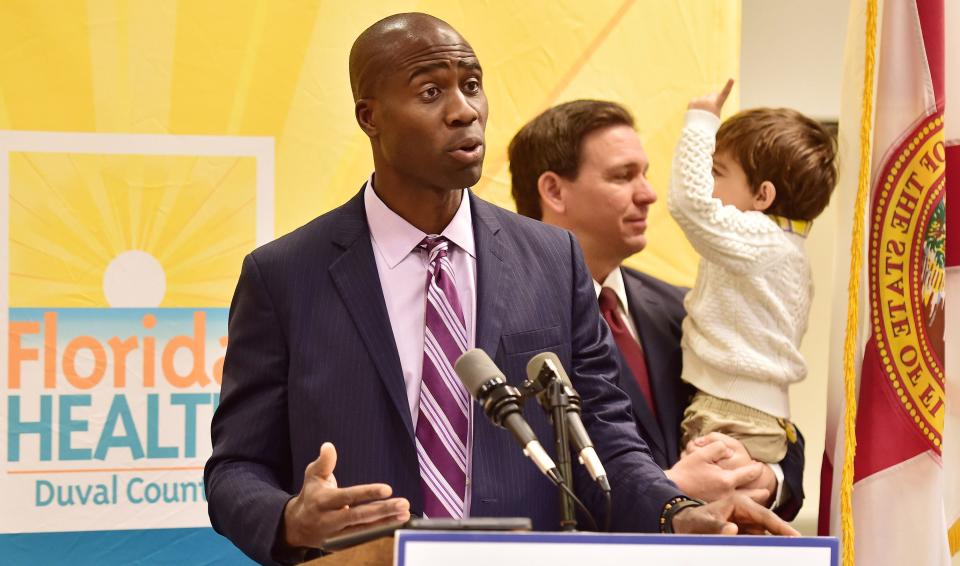 Dr. Joseph Ladapo, the Surgeon General of the State of Florida addresses the media during a January 2022 press conference in Jacksonville, with Florida Gov. Ron DeSantis and his so Mason in the background.