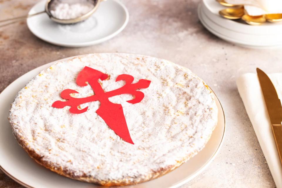 Eine weitere süße Spezialität aus Spanien ist Mandelkuchen. Die "Tarta de Santiago" stammt aus Galicien und ist mit einem Jakobskreuz verziert. Der Kuchen schmeckt wegen des hohen Gehalts an Mandeln nach Marzipan und ist als klassische Wegzehrung bei Pilgern auf dem Jakobsweg beliebt - vor allem nach der Ankunft in der Pilgerhauptstadt Santiago de Compostela. (Bild: iStock/vasantytf)