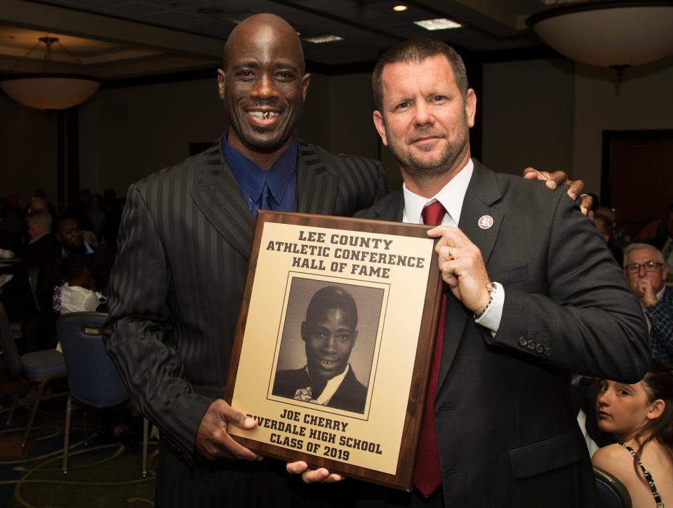 Joe Cherry, left, a 1998 Riverdale High School graduate, is inducted into the Lee County Athletic Conference Hall of Fame on Thursday in Fort Myers. Cherry played basketball at Riverdale. Riverdale High School principal Scott Cook, right, is among Cherry's supporters.