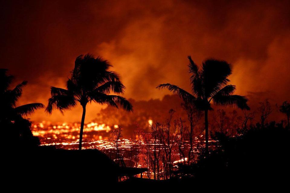 Lava flows past trees on the outskirts of Pahoa during ongoing eruptions of the Kilauea Volcano in Hawaii (REUTERS)