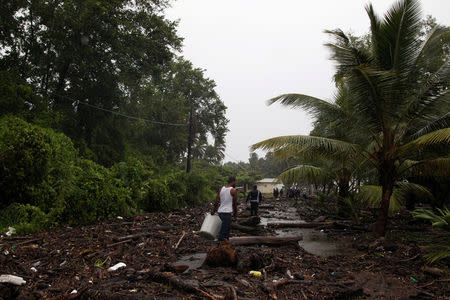 People walk on a street covered in debris in Nagua. REUTERS/Ricardo Rojas