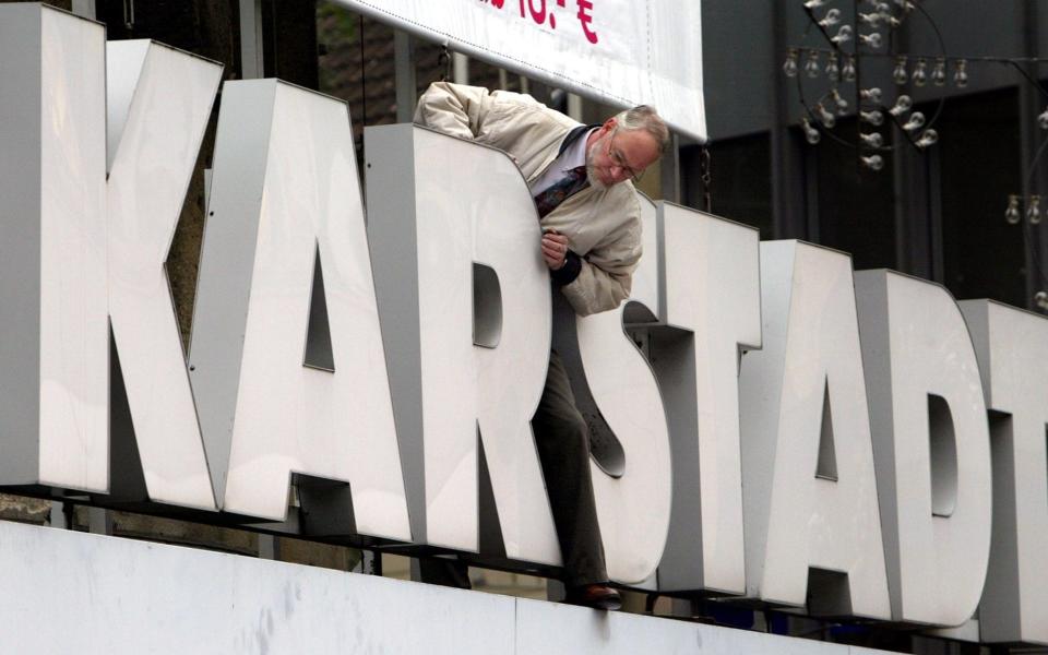 A worker fixes the letters at a Karstadt store in downtown Essen, western Germany, Tuesday Sept. 28, 2004. Struggling German retailer KarstadtQuelle said Tuesday it plans to sell 77 of its department stores as soon as possible as it responds to slumping sales in economically lagging Germany. KarstadtQuelle announced Monday that it will undergo a 1.4 billion (US$1.72 billion) restructuring plan to refocus the group on its core operations, with German media speculating that the company was planning massive lay-offs and a capital increase. (AP Photo/Frank Augstein) - FRANK AUGSTEIN/AP