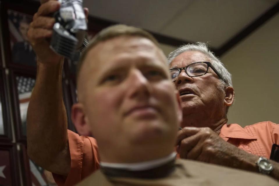 Then-Maj. Jeremy Secrest has his hair cut by Travis Bell in September 2017. Bell has served as a barber on Fort Bragg for more than 50 years.