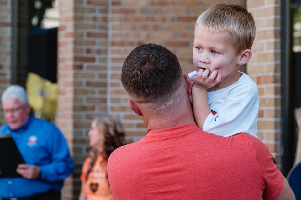 Cash Stephen, 4, who is autistic, is held by his father Josh, as Mayor Joel Day, at far left, reads a special proclamation during the ribbon cutting ceremony for Lacey PAC, a newly opened adaptive movement center for people with special needs, ages 3 through adult, Saturday, Sept. 16 in New Philadelphia.