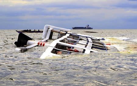 A fishing boat passes the Super Shuttle Ferry 7 which capsized in strong winds and huge waves unleashed by Typhoon Kalmaegi, locally named Luis, in Manila Bay September 15, 2014. REUTERS/Romeo Ranoco