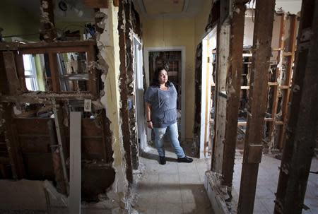 Nicole Chati poses for a portrait in what is left of her home after Superstorm Sandy in the Staten Island borough of New York, September 20, 2013. REUTERS/Carlo Allegri