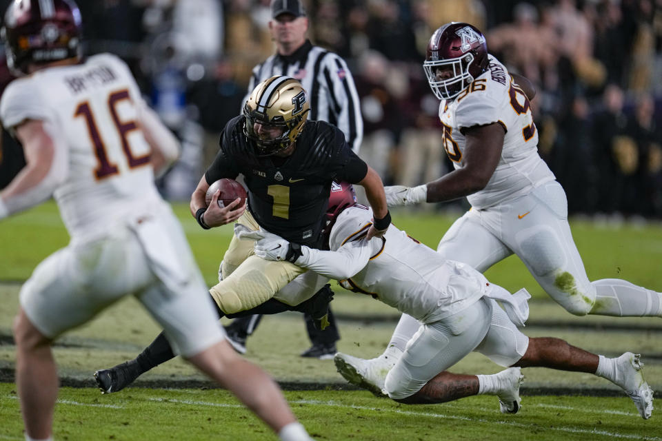 Purdue quarterback Hudson Card (1) is tackled by Minnesota linebacker Devon Williams (9) during the second half of an NCAA college football game in West Lafayette, Ind., Saturday, Nov. 11, 2023. (AP Photo/Michael Conroy)