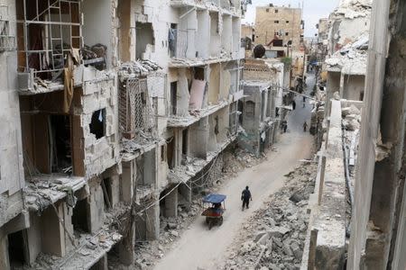 Residents walk near damaged buildings in the rebel held area of Old Aleppo, Syria May 5, 2016. REUTERS/Abdalrhman Ismail