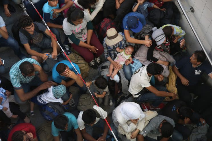 Some of approximately 190 migrants, including a baby, who arrived on a train from Budapest and were detained by German police wait to be initially registered by the police at the railway station on August 31, 2015 in Rosenheim, Germany. (Photo: Sean Gallup/Getty Images)